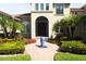 Elegant front entry with wrought iron door accents, a water feature, and well-maintained landscaping at 11013 Ullswater Ln, Windermere, FL 34786