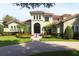 Elegant Mediterranean-style home featuring a tile roof, lush landscaping, and a circular driveway with a front water feature at 11013 Ullswater Ln, Windermere, FL 34786
