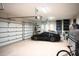 Spacious garage with a sleek black sports car, ample storage, and organized shelving units at 11013 Ullswater Ln, Windermere, FL 34786