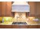 Kitchen features a granite countertop, tiled backsplash, gas cooktop, and custom cabinetry at 11013 Ullswater Ln, Windermere, FL 34786