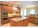 Gourmet kitchen featuring a center island, custom cabinetry, and stainless-steel appliances at 11013 Ullswater Ln, Windermere, FL 34786