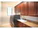 Functional laundry room includes modern washer and dryer, ample cabinet space, and a granite countertop at 11013 Ullswater Ln, Windermere, FL 34786