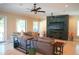 Comfortable living room features a large gray sofa and a stone accent wall with a fireplace and mounted TV at 11013 Ullswater Ln, Windermere, FL 34786