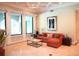 Living room featuring an orange sectional sofa, coffered ceiling, and large windows offering natural light at 11013 Ullswater Ln, Windermere, FL 34786