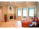 Bright living room features an orange sectional sofa and a fireplace with large windows at 11013 Ullswater Ln, Windermere, FL 34786