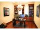 Home office with custom shelving, a large desk, and a modern chandelier providing ample lighting at 11013 Ullswater Ln, Windermere, FL 34786