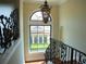 Bright stairwell with an ornate window, chandelier, iron railing, and wood steps at 11013 Ullswater Ln, Windermere, FL 34786