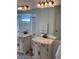 Bright bathroom featuring dual vanity sinks with brushed bronze fixtures and a large mirror with decorative lighting at 116 Blackwater Ct, Kissimmee, FL 34743