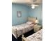 Bright blue bedroom with two twin beds, ceiling fan, and a window for natural light at 116 Blackwater Ct, Kissimmee, FL 34743