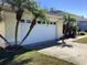 Home's garage door with three palm trees next to it, and a well-maintained lawn at 116 Blackwater Ct, Kissimmee, FL 34743