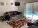 Cozy living room showcases a comfortable sofa and sliding door to the pool area at 116 Blackwater Ct, Kissimmee, FL 34743