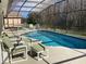 Inviting pool in screened lanai with outdoor seating and lush backyard at 116 Blackwater Ct, Kissimmee, FL 34743