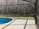 Secluded pool in screened enclosure with a view of mature trees and landscaped backyard at 116 Blackwater Ct, Kissimmee, FL 34743