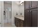 Well-lit bathroom featuring granite counters, dark wood cabinetry, and shower-tub combo at 11755 Waterstone Loop Dr, Windermere, FL 34786