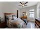 Comfortable bedroom featuring a ceiling fan, wood floors, and a well-lit dresser at 11755 Waterstone Loop Dr, Windermere, FL 34786