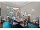 Elegant dining room with a large window, shutter blinds, and modern light fixtures at 11755 Waterstone Loop Dr, Windermere, FL 34786