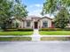 Charming single-story home with lush landscaping and a brick walkway leading to the front door at 11755 Waterstone Loop Dr, Windermere, FL 34786
