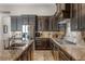 Stylish kitchen featuring granite countertops, dark cabinets, stainless steel appliances, and tile backsplash at 11755 Waterstone Loop Dr, Windermere, FL 34786