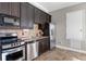 Well-equipped kitchenette with stainless steel appliances and dark cabinetry for convenient and stylish living at 11755 Waterstone Loop Dr, Windermere, FL 34786
