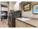 Laundry room with a stainless steel washer and dryer, sink, and ample storage at 11755 Waterstone Loop Dr, Windermere, FL 34786