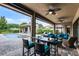 Spacious covered patio features an outdoor dining table and cozy seating, offering serene views of the inviting pool area at 11755 Waterstone Loop Dr, Windermere, FL 34786
