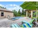 Beautiful backyard with a pool, spa, lounge chairs, and patio with green umbrella at 11755 Waterstone Loop Dr, Windermere, FL 34786