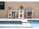 Outdoor bar table set next to a well maintained pool with seating at 11755 Waterstone Loop Dr, Windermere, FL 34786