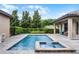 Inviting backyard pool and spa surrounded by lush landscaping and a stone patio at 11755 Waterstone Loop Dr, Windermere, FL 34786