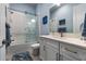 Well-lit bathroom featuring a shower-tub combination, white vanity with modern fixtures, and blue accents at 1212 Civitas Way, Winter Garden, FL 34787