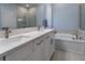 Bathroom with a large vanity with double sinks, a soaking tub and glass enclosed shower at 1212 Civitas Way, Winter Garden, FL 34787