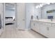 Bathroom featuring double sinks, modern fixtures, and a glimpse into the adjacent bedroom at 1212 Civitas Way, Winter Garden, FL 34787