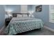 Cozy bedroom featuring light blue walls, plantation shutters, and a comfortable bed with decorative pillows at 1212 Civitas Way, Winter Garden, FL 34787