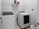 Well-lit laundry room featuring a modern washer and dryer set with storage shelf at 1212 Civitas Way, Winter Garden, FL 34787