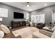 Comfortable living room featuring a ceiling fan, a large TV, and a modern entertainment center at 1212 Civitas Way, Winter Garden, FL 34787