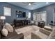 Inviting living room with hardwood flooring, a ceiling fan, a large TV, and a door to the outside at 1212 Civitas Way, Winter Garden, FL 34787