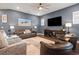 Spacious living room with hardwood floors, a decorative rug, a large TV, and stylish furniture at 1212 Civitas Way, Winter Garden, FL 34787