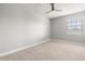 This simple bedroom offers neutral carpet and paint, a ceiling fan, and a window for plenty of light at 1272 Patterson Ter, Lake Mary, FL 32746