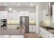 Bright kitchen features white cabinets, stainless appliances, mosaic backsplash and a large center island at 1272 Patterson Ter, Lake Mary, FL 32746