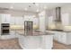 Bright kitchen features white cabinets, stainless appliances, mosaic backsplash and a large center island at 1272 Patterson Ter, Lake Mary, FL 32746