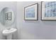 Powder room featuring pedestal sink, blue decorative art, and neutral paint at 1304 Isleta Loop, Kissimmee, FL 34741