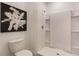 This minimalist white bathroom showcases a modern toilet and an all-white shower with built-in shelves at 1310 Isleta Loop, Kissimmee, FL 34741