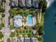 An aerial view highlights a community pool nestled beside a serene lake at 1356 Coralstone Dr, Celebration, FL 34747