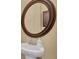 Pedestal sink in bathroom with an oval wood-framed mirror and neutral paint at 1356 Coralstone Dr, Celebration, FL 34747
