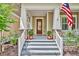 Close up of a inviting front porch with stone accents, classic columns, a stylish front door, and manicured landscaping at 1356 Coralstone Dr, Celebration, FL 34747