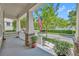 Inviting front porch featuring classic columns, swing, view of street with sidewalk and manicured landscaping at 1356 Coralstone Dr, Celebration, FL 34747