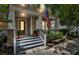 Charming front porch with stone accents, columns, American flag, and landscaped garden at 1356 Coralstone Dr, Celebration, FL 34747