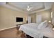 Main bedroom featuring tray ceilings, wood flooring and large television at 1356 Coralstone Dr, Celebration, FL 34747