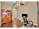 Home office with hardwood floors, plantation shutters, built-in bookcase, and view of living area at 1356 Coralstone Dr, Celebration, FL 34747