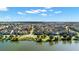 Aerial view of a residential community showcasing the neighborhood layout and surrounding lakes under a blue, partly cloudy sky at 13661 Granger Ave, Orlando, FL 32827