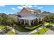 Elegant two-story home showcases a metal roof and a covered porch with manicured landscaping at 13661 Granger Ave, Orlando, FL 32827